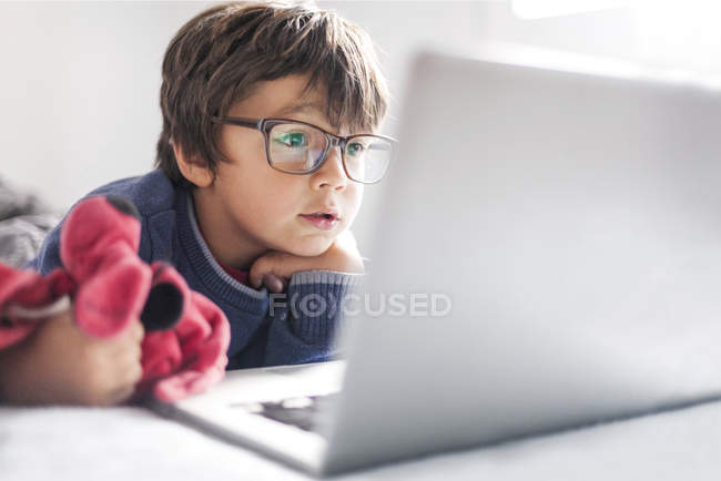 Porträt eines kleinen Jungen mit überdimensionaler Brille beim Blick auf den Laptop — Stockfoto