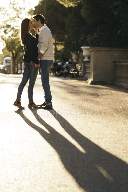 Pareja enamorada besándose en la ciudad al atardecer — Juntos, adultos -  Stock Photo | #177235278