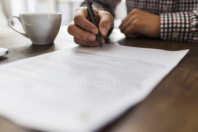 Imagen recortada del documento de firma de hombre en la tabla - foto de stock
