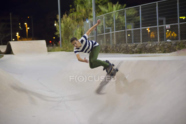 Молода людина, скейтбордингу в муніципалітет скейтпарк вночі — стокове фото