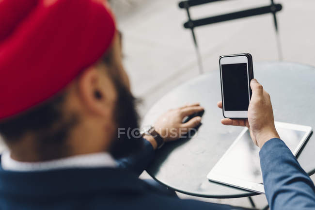 Rückansicht von indischen Geschäftsmann in manhattan sitzt am Tisch mit Telefon, ny, usa — Stockfoto