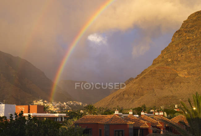 Espanha, Ilhas Canárias, La Gomera, Valle Gran Rey, arco-íris acima da aldeia montanhosa — Fotografia de Stock