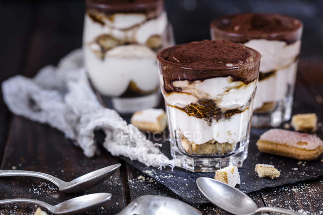 Closeup view of Tiramisu glasses with cookies and spoons — Stock Photo