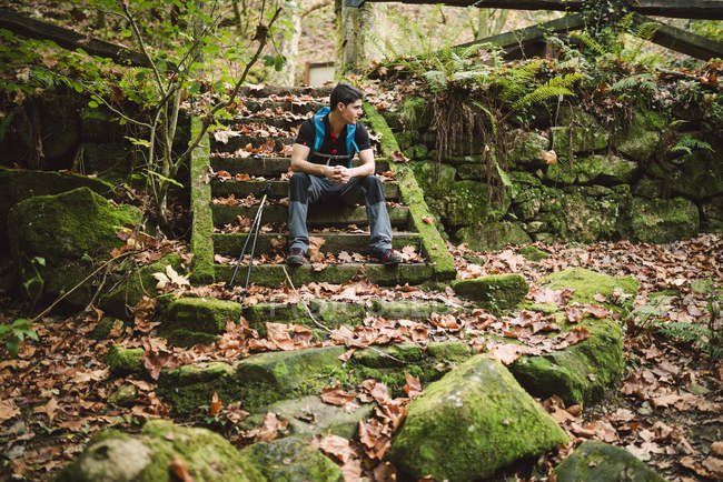 Escursionista seduto sulle scale nella natura e avere una pausa — Foto stock