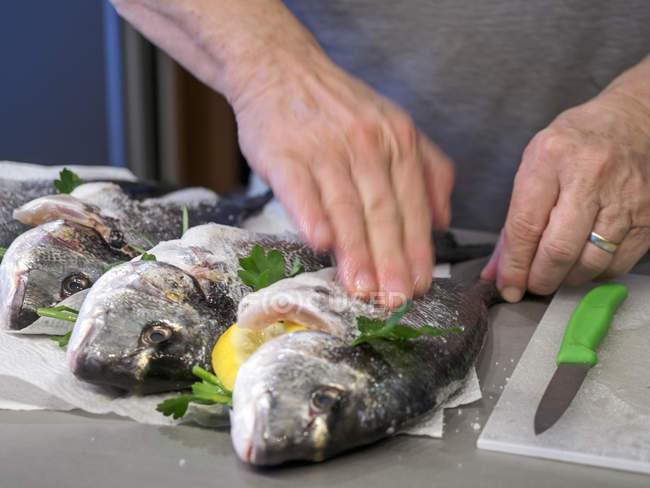 Male hands Preparing gilthead seabream for grilling — Stock Photo