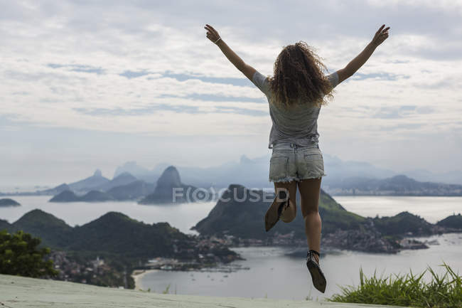 Brasil, mujer saltando sobre un mirador en Río de Janeiro - foto de stock