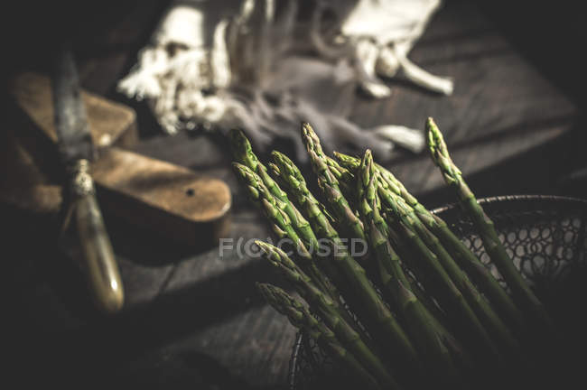 Green asparagus in wire basket — Stock Photo