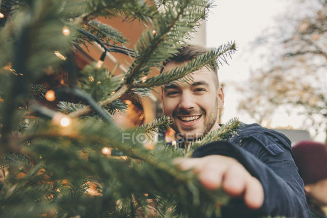 Happy young man with a tree on the Christmas Market — Stock Photo