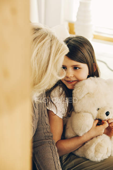 Nonna guardando nipote in possesso di orsacchiotto — Foto stock