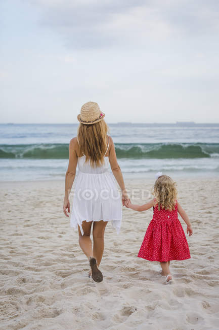 Regeneración pánico creativo Brasil, Río de Janeiro, madre e hija caminando por la playa de Copacabana —  arena, Chanclas - Stock Photo | #177536636