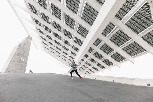 Donna che fa jogging sotto pannello solare — Foto stock