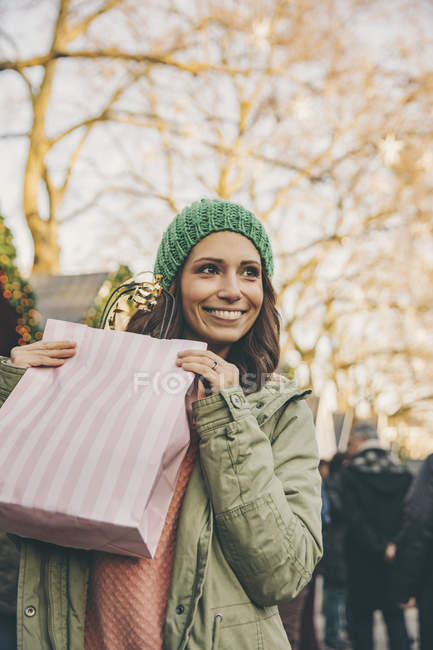 Mulher feliz segurando saco de presente no mercado de Natal — Fotografia de Stock