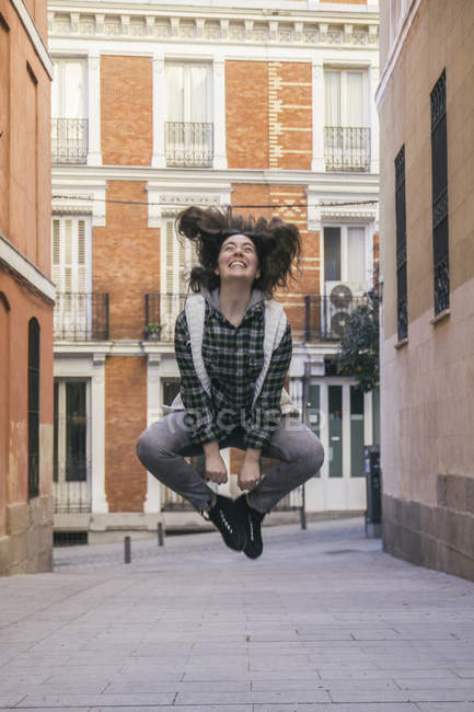 Spagna, Madrid, giovane donna felice che salta in aria in una strada — Foto stock