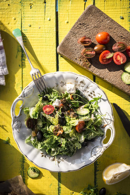 Insalata greca con rucola, formaggio, olive, pomodori, cetrioli, cipolla e noci caramellate — Foto stock