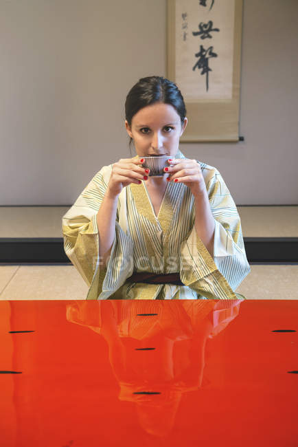 Portrait de femme portant du yukata buvant du thé dans une pièce traditionnelle japonaise — Photo de stock