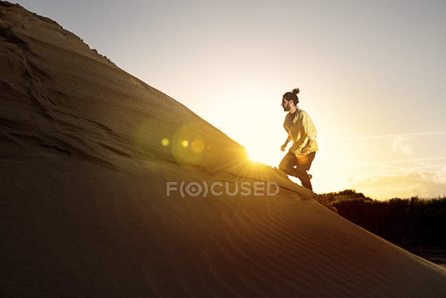 Man running uphill in desert — Stock Photo