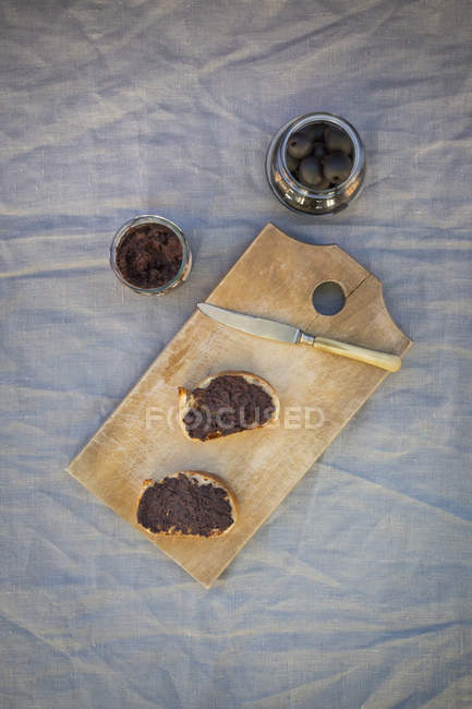 Black olives and slices of white bread with olive paste — Stock Photo