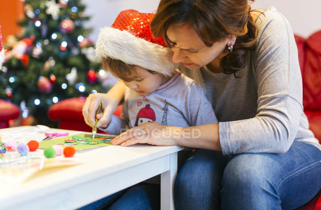 Mãe ajudando pequena filha mexer decoração de Natal — Fotografia de Stock