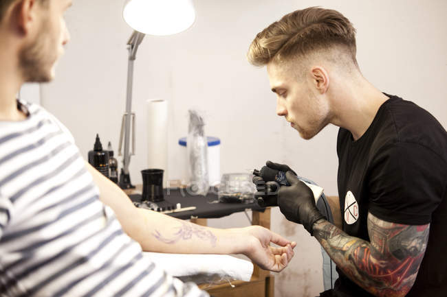 Tatuagem no trabalho em seu estúdio de tatuagem — Fotografia de Stock