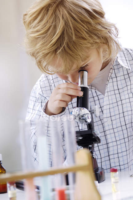 Petit garçon blond au microscope — Photo de stock