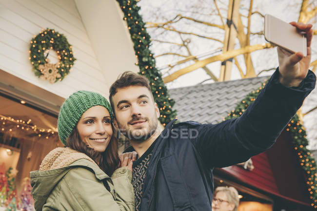 Couple taking a selfie on the Christmas Market — Stock Photo