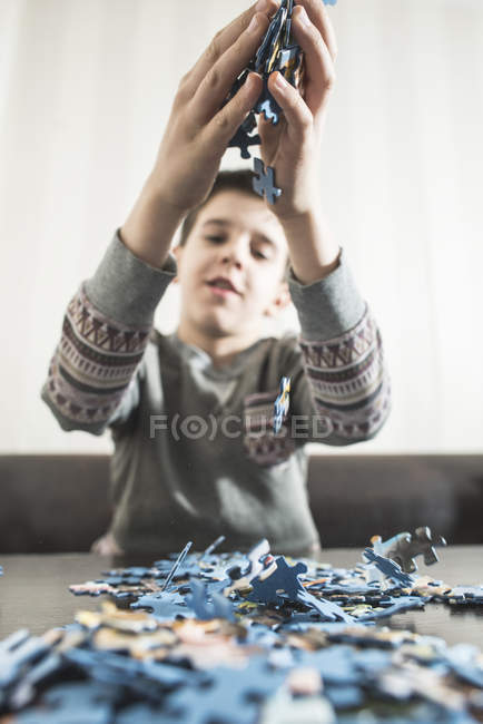 Vista cortada de menino segurando peças de quebra-cabeça — Fotografia de Stock