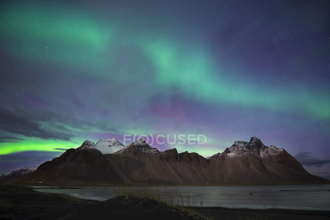 Islândia, Hoefn, luzes do norte sobre as montanhas Vesturhorn — Fotografia de Stock