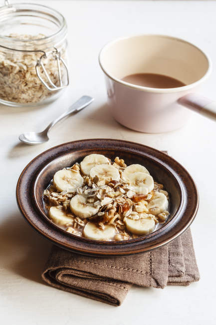 Dish of banana oatflakes granola and cocoa — Stock Photo