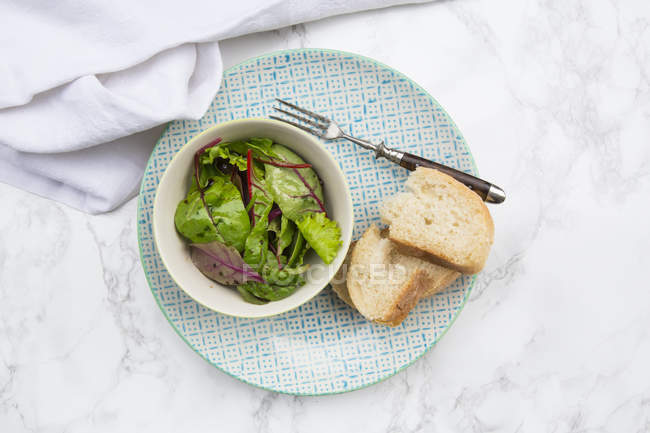 Миска приготованого змішаного салату і скибочки білого хліба — стокове фото