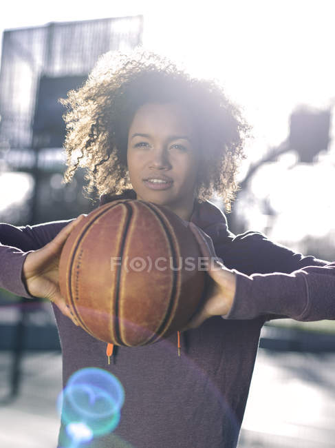 Portrait of young woman passing basketball at backlight — Stock Photo