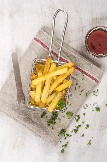 Deep-fried french fries in chip basket with ketchup — Stock Photo