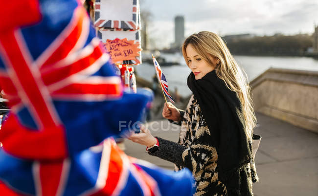 Uk, london, junge Frau blickt auf einen Souvenirstand — Stockfoto