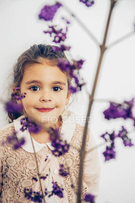 Ritratto di ragazza sorridente dietro il fiore — Foto stock