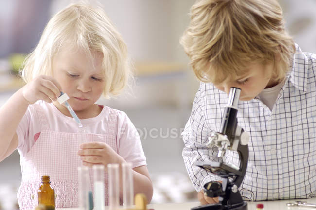 Zwei kleine Kinder spielen mit Utensilien aus dem Chemielabor — Stockfoto