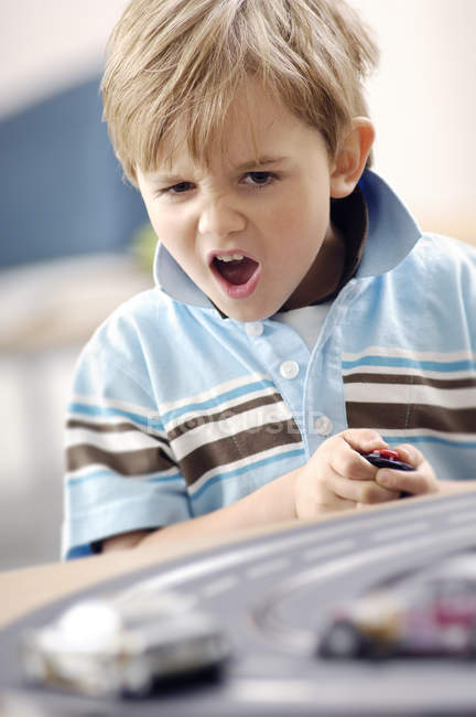 Portrait of blond little boy playing with Carrera — Stock Photo