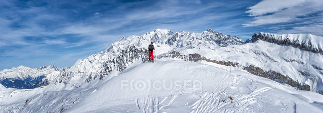 Tiro à distância de um jovem durante o alpinismo de esqui durante o dia — Fotografia de Stock