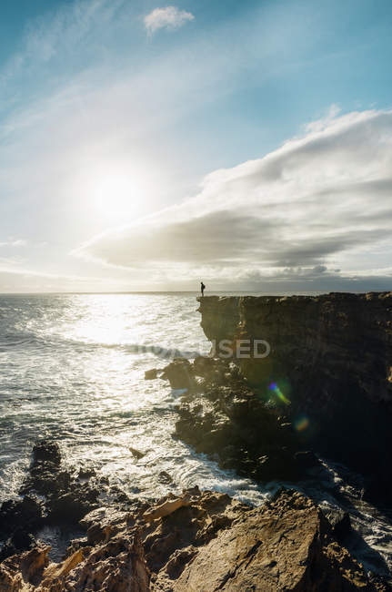 Spain, Canary Islands, Fuerteventura, La Pared, man standing on a cliff at sunset — Stock Photo