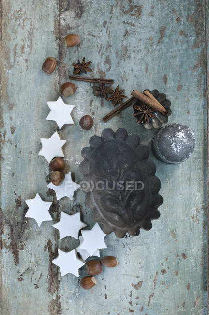 Panelas de bolo com estrelas de canela, paus de canela, avelãs e anis estrelado em madeira — Fotografia de Stock