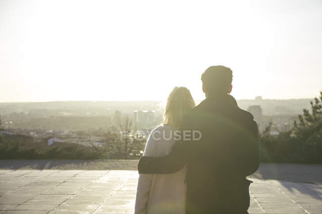 Espanha, Madrid, vista para trás do jovem casal apaixonado no backlight — Fotografia de Stock