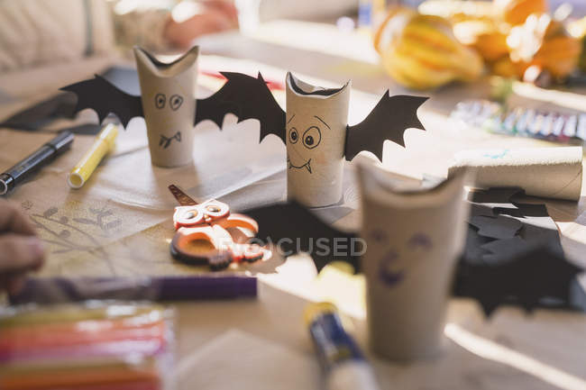 Tinkered paper bats on wooden desk — Stock Photo