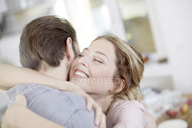 Young couple hugging in kitchen — Stock Photo