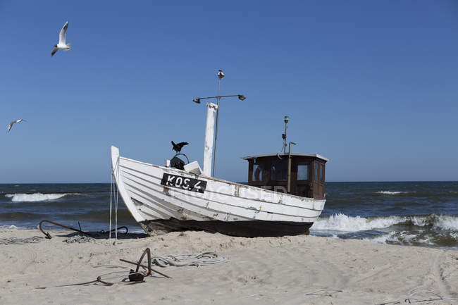 Barco de pesca en la playa - foto de stock