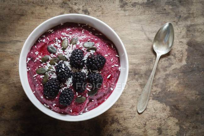 Smoothie bowl with blackberries, coconuts and pumpkin seeds — Stock Photo