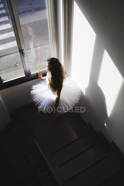 Ballerine dans un tutu à la fenêtre dans le hall, frais généraux — Photo de stock