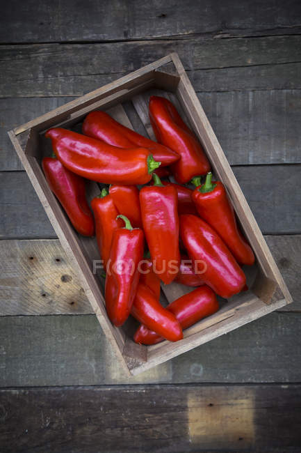 Red pointed peppers in wodden box — Stock Photo