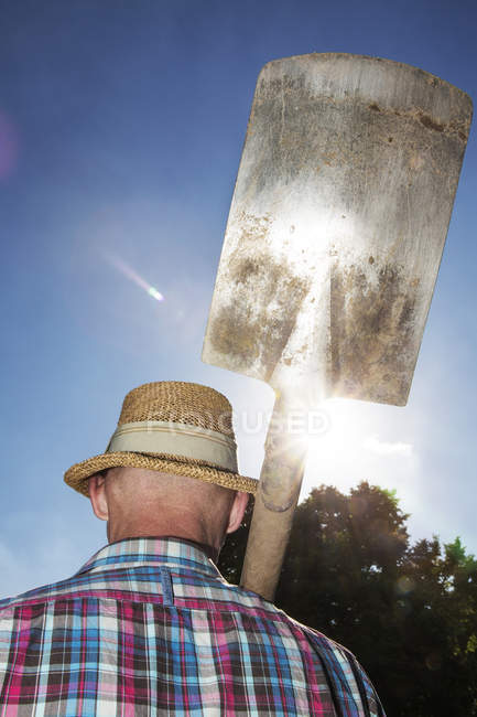 Back view of allotment gardener with spade on his shoulder — Stock Photo