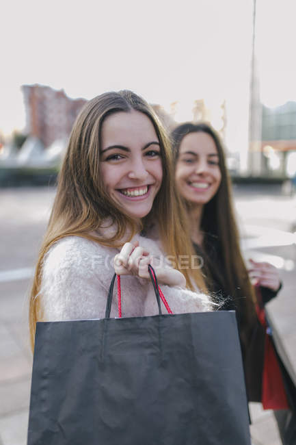 Mujeres jóvenes con bolsas de compras en la calle de la ciudad - foto de stock