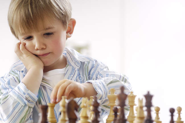 Ritratto di bambino pensante che gioca a scacchi — Foto stock