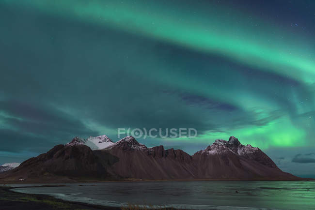 Islândia, Hoefn, luzes do norte sobre as montanhas Vesturhorn — Fotografia de Stock