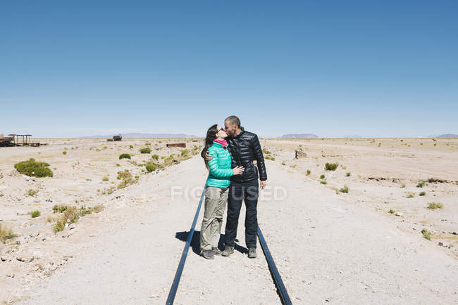 Bolivie, cimetière du train d'Uyuni, baiser en couple sur le chemin de fer — Photo de stock